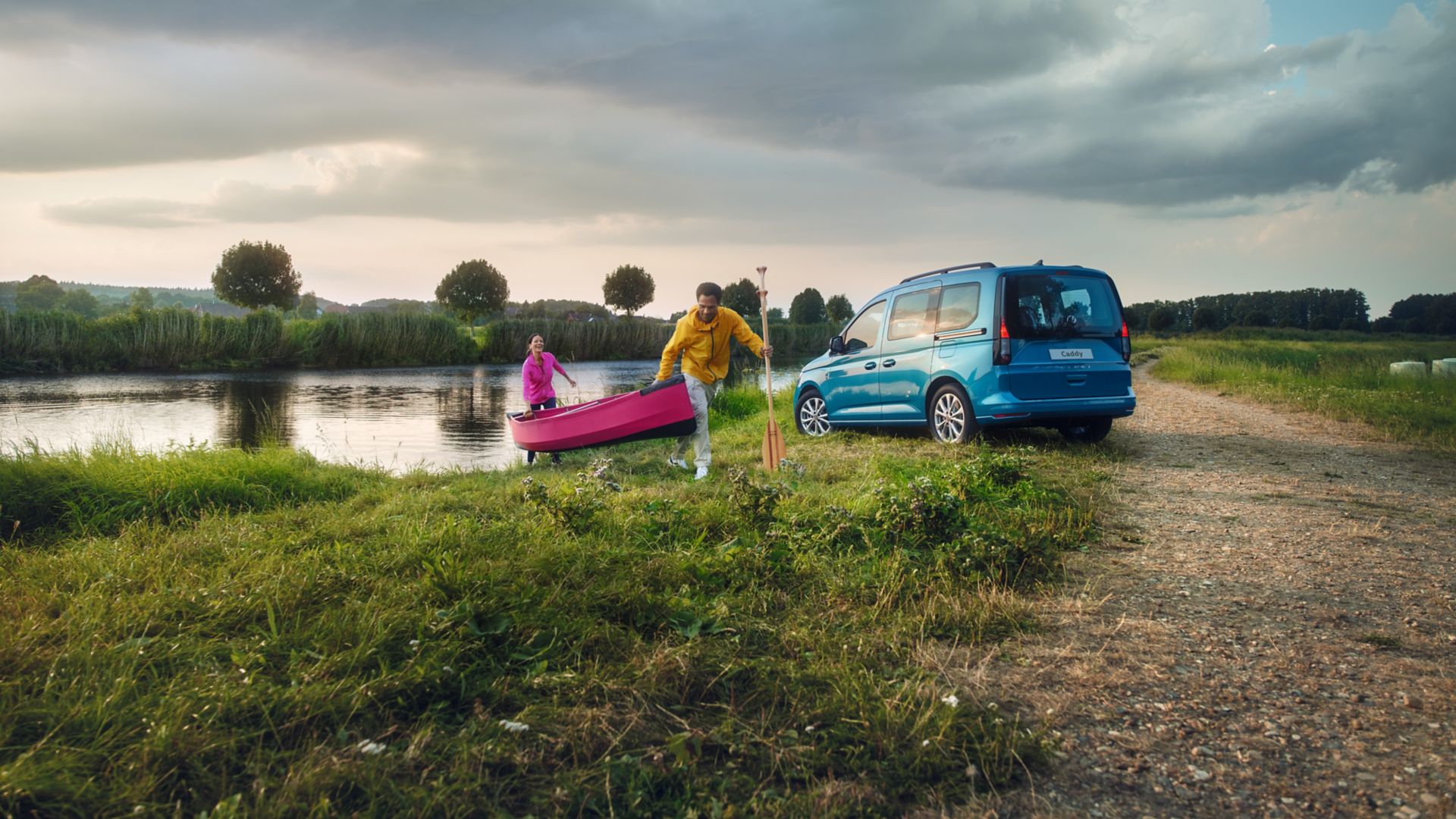 Blauer Caddy California seitliches Heck am See