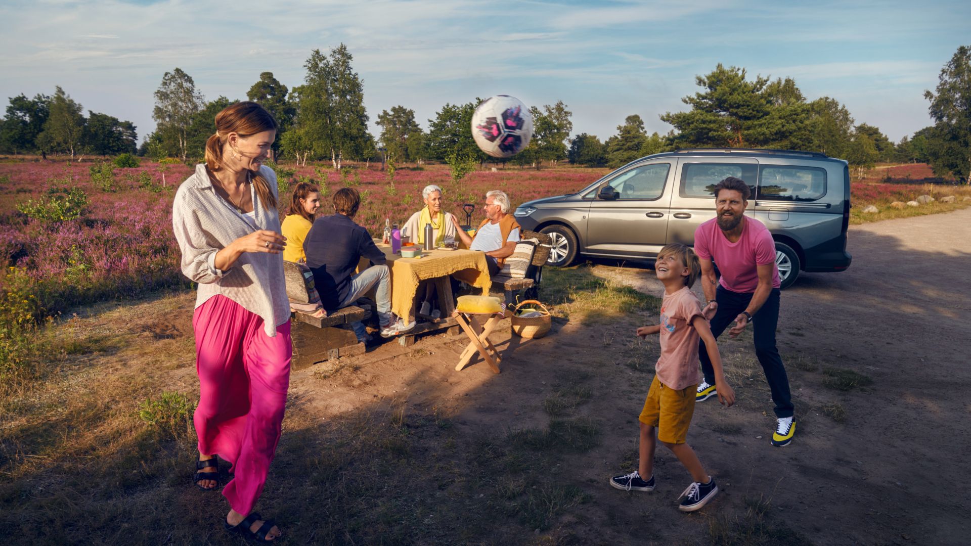 AMAG neuer VW Caddy California Seitenansicht mit Familie in der Heide