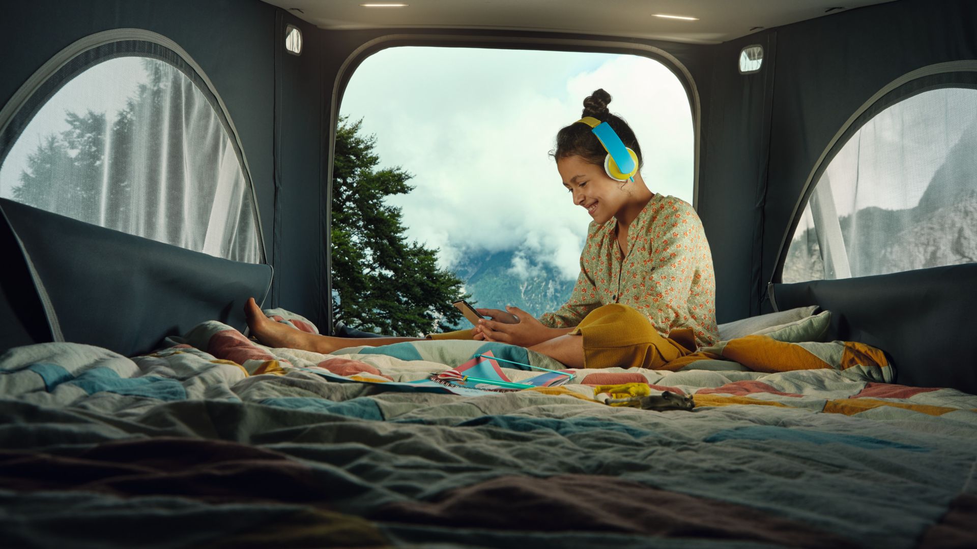 Girl sitting on the bed inside the VW California Ocean