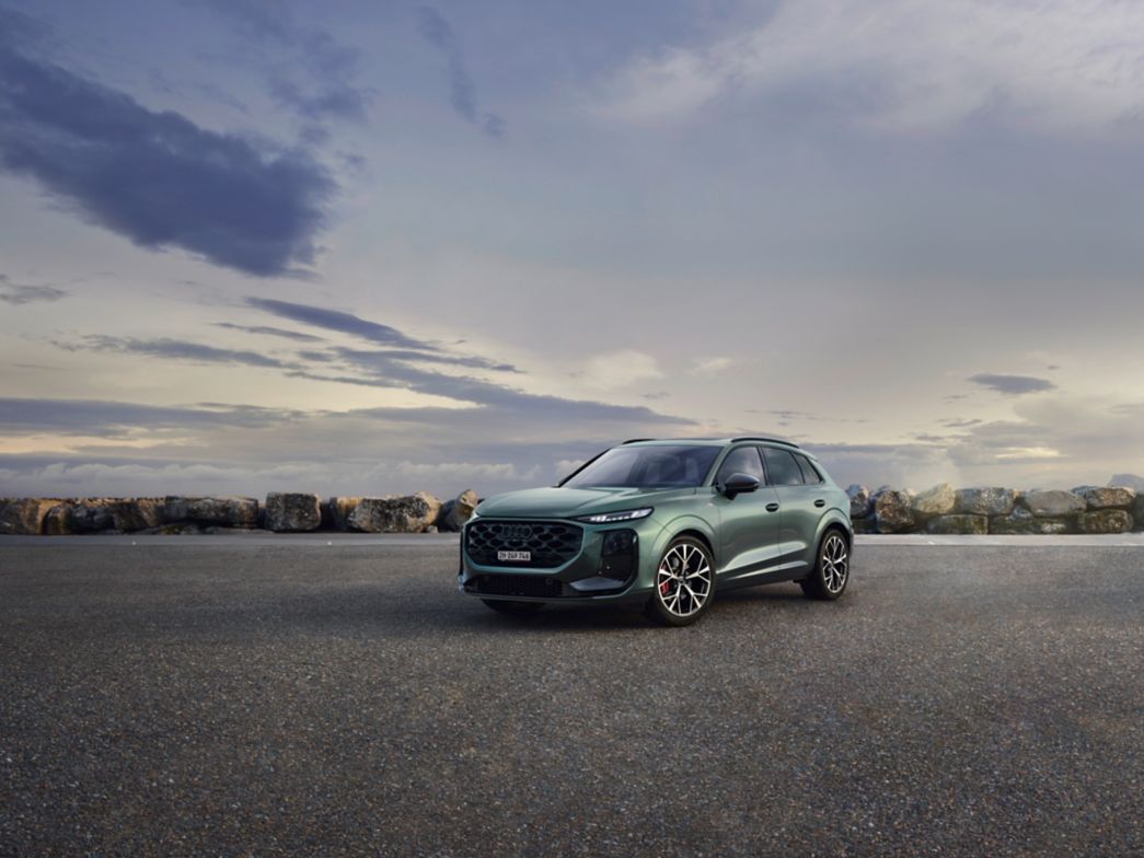 Novelle Audi Q3 verte vue de face à côté d'un arbre