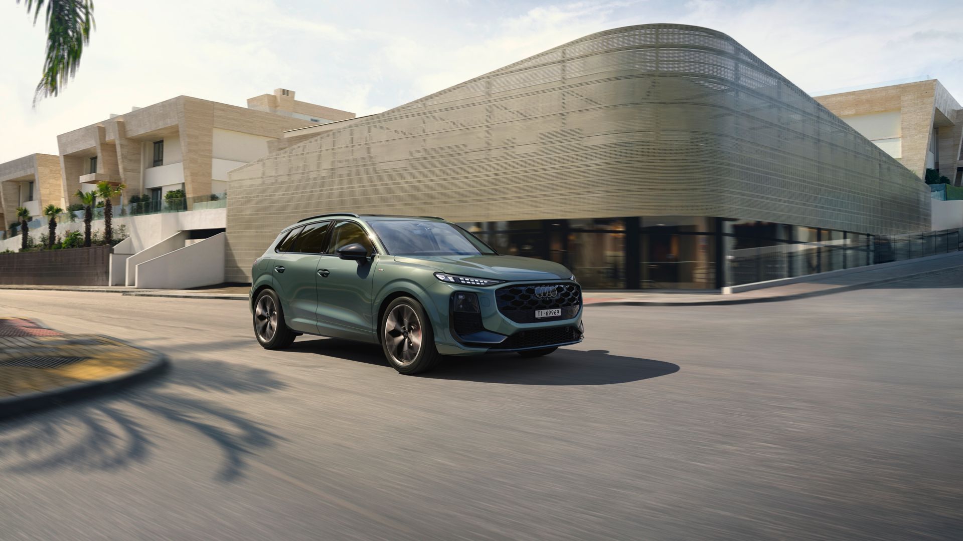Green Audi Q3 side view with a city in the background