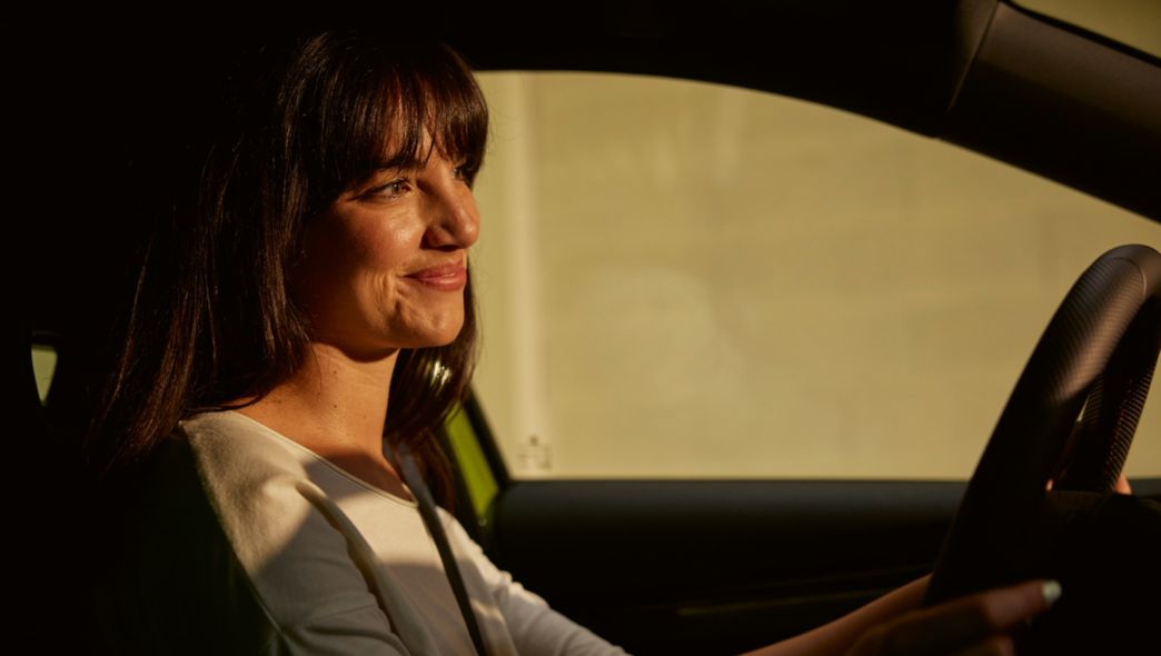 AutoSock - Drei Personen sitzen lachend im Schnee beim Auto