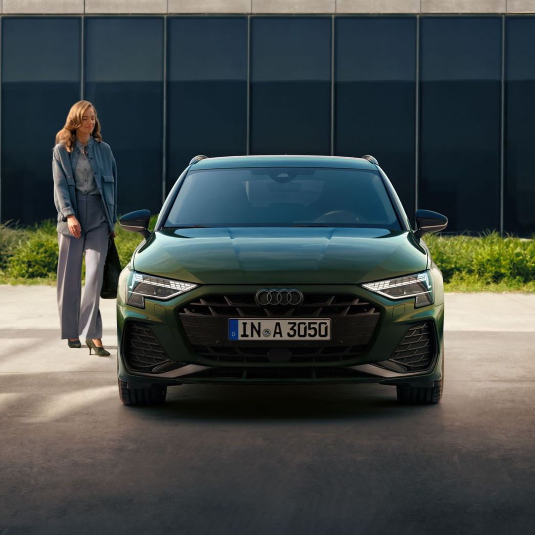 Green Audi A3 Sportback front view with woman next to it