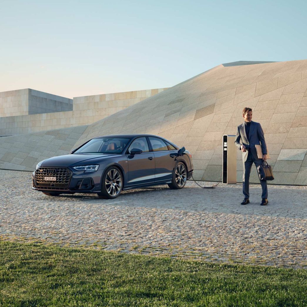 Black Audi A8, side view, at a charging station