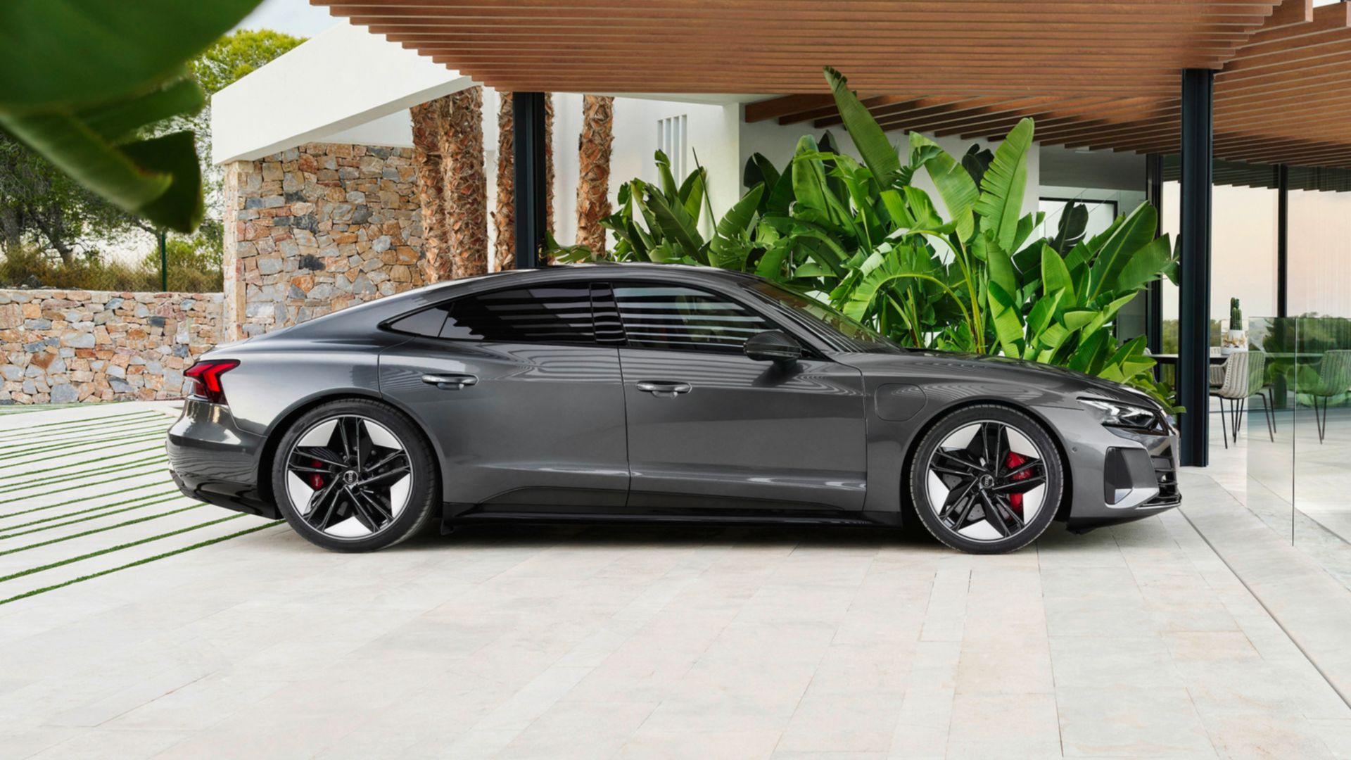 Grauer Audi S e-tron GT Rückansicht auf einer Küstenstrasse