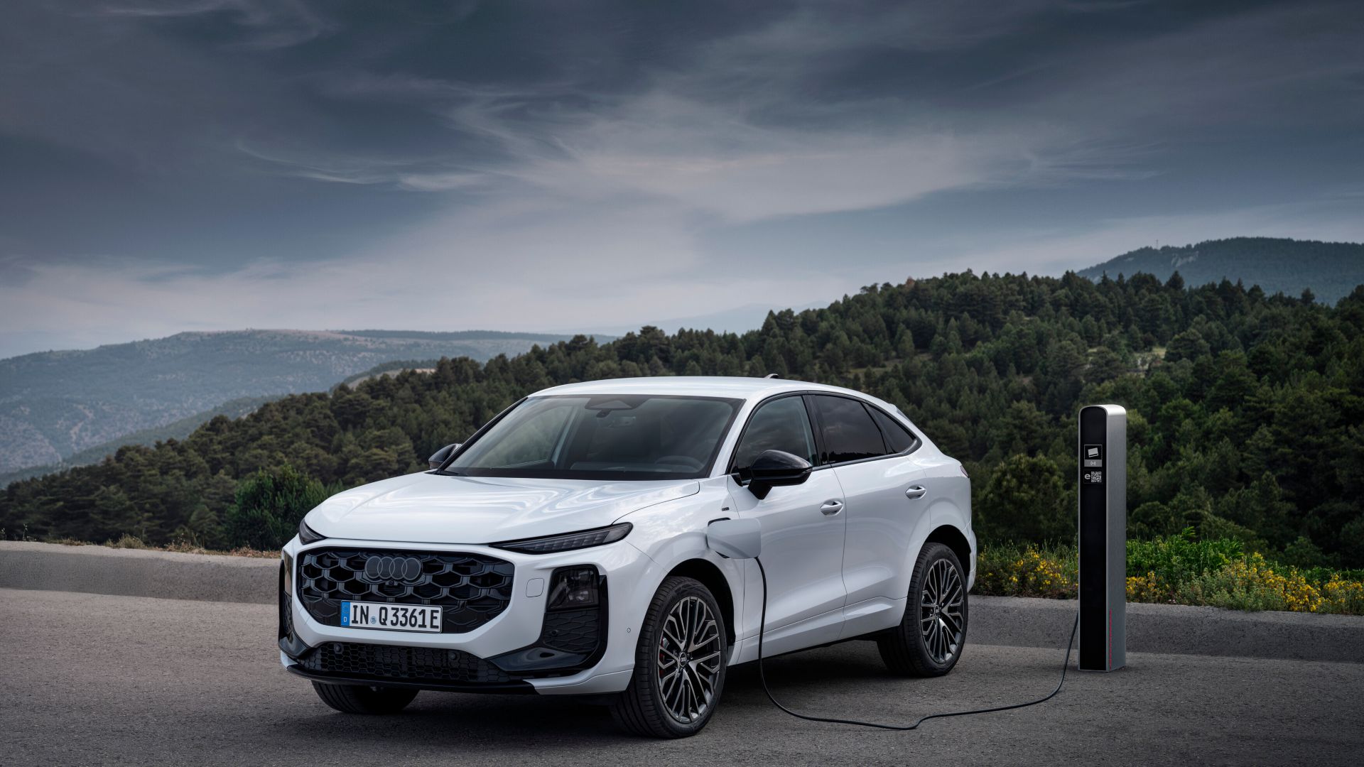 Audi Q3 e-hybrid blanc vue de face et latérale à côté d'une station de recharge