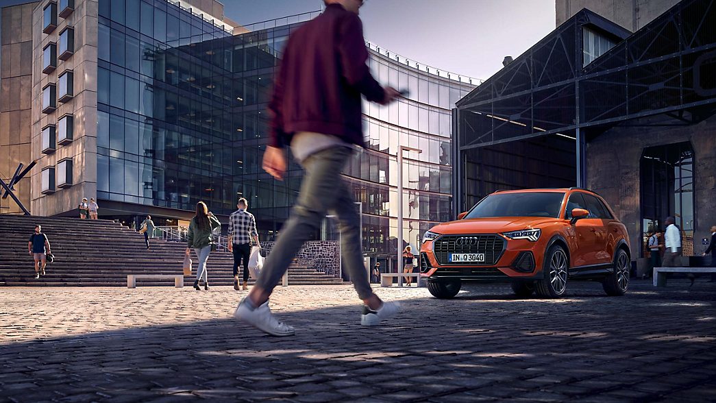 Audi Q3 in Fussgängerzone, Mann im Vordergrund 