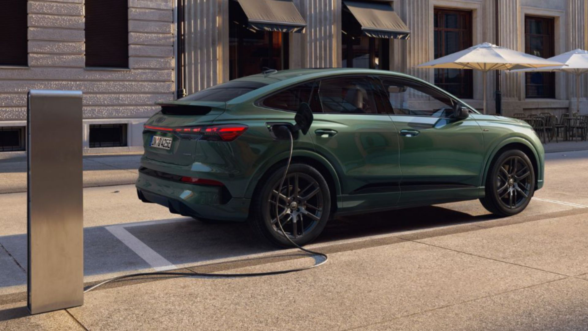 Grüner Audi Q4 e-tron Seitenansicht vor Gebäude