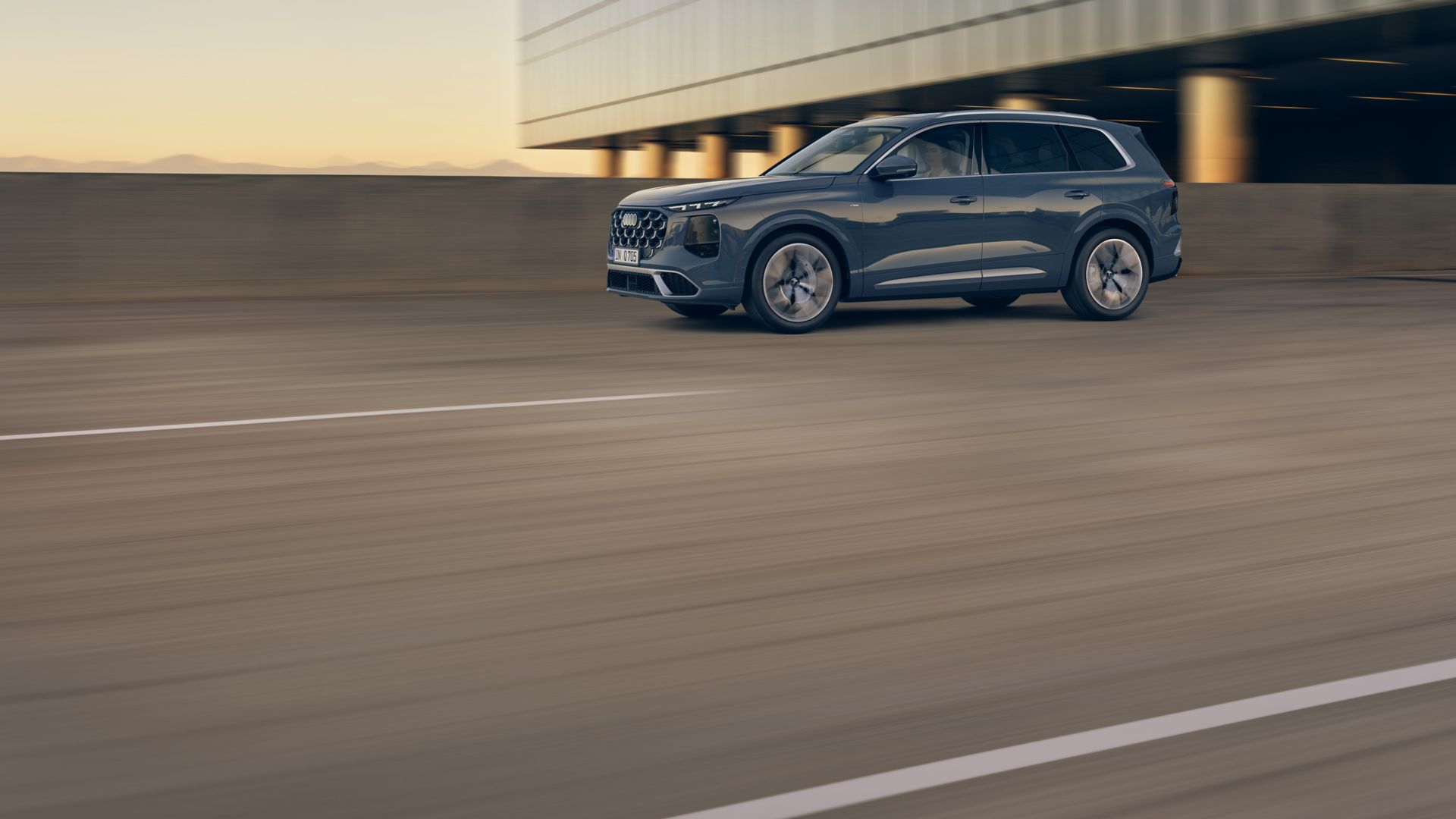 Audi Q7 vue latérale devant une maison