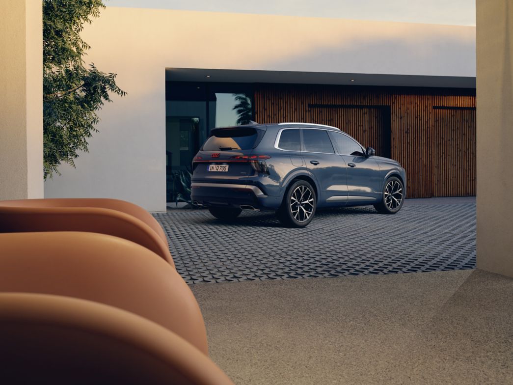 Blauer Audi Q7 seitlich vor einem Haus