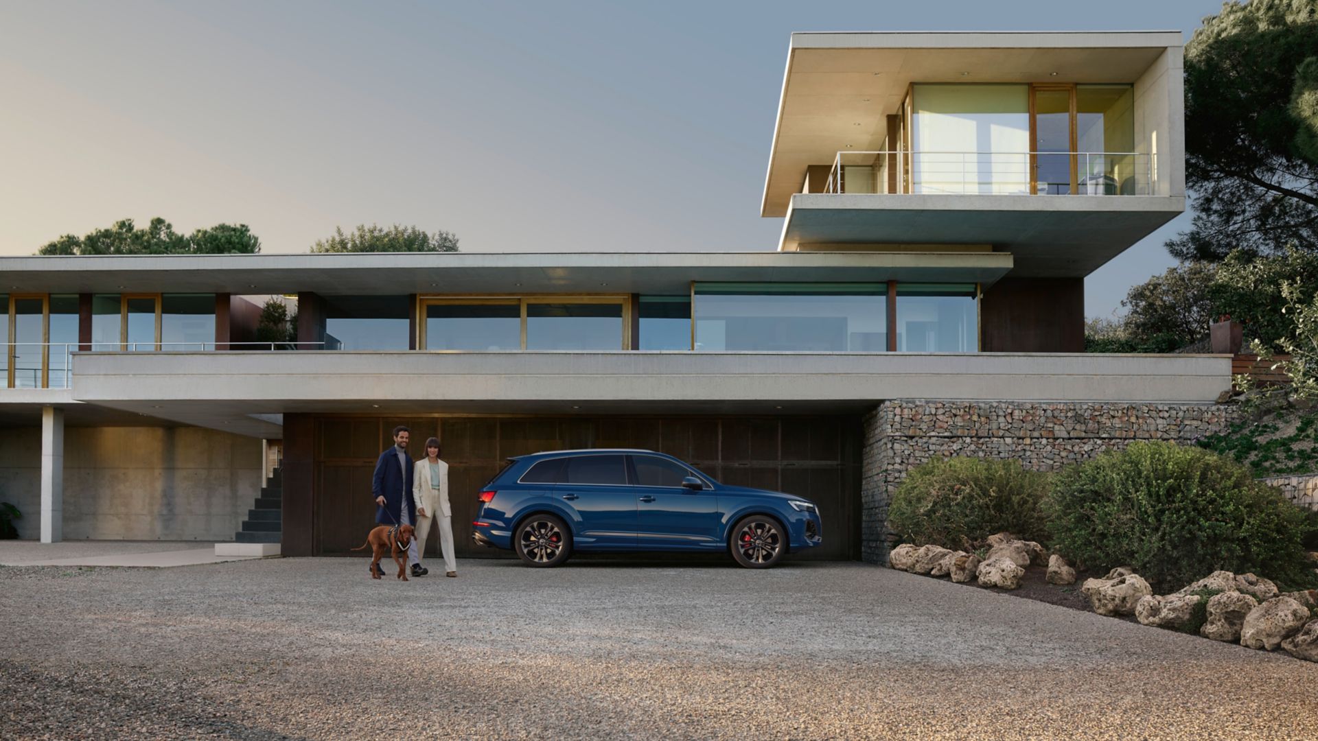 Blauer Audi Q7 seitlich vor einem Haus