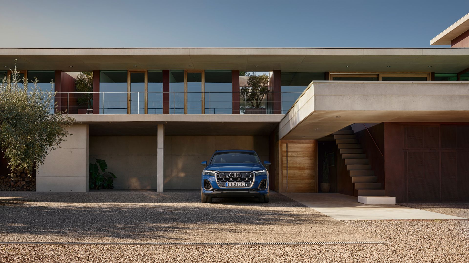Blauer Audi Q7 Frontansicht vor einem Haus