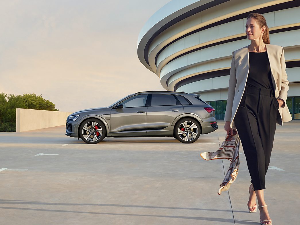 Frau mit Audi Q8 im Hintergrund