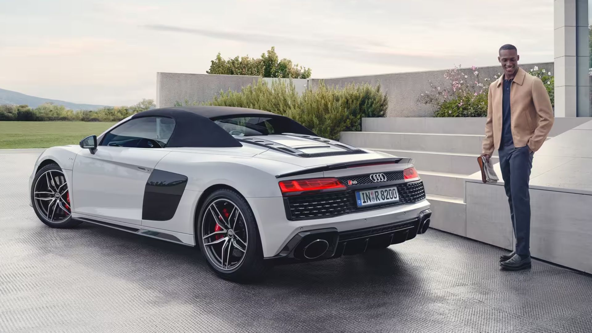 Audi R8 bianca vista da dietro con un uomo accanto 