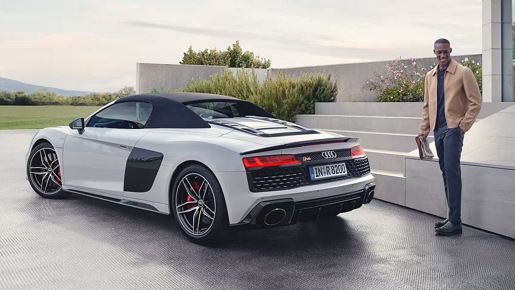 White Audi R8 rear view with a man next to it 