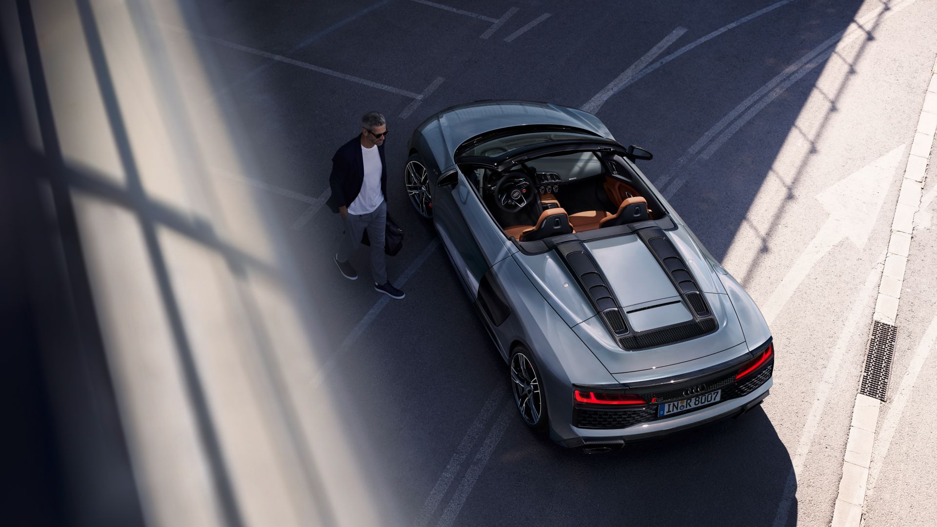 Audi R8 Spyder grigia dall'alto con uomo a fianco