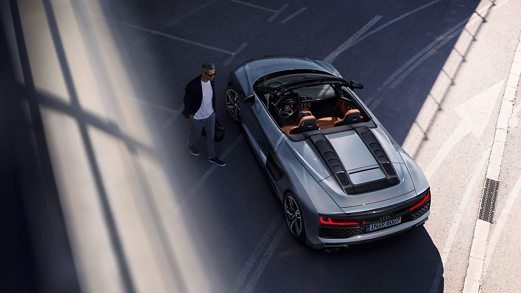 Audi R8 Spyder en gris vue d'en haut avec un homme à côté
