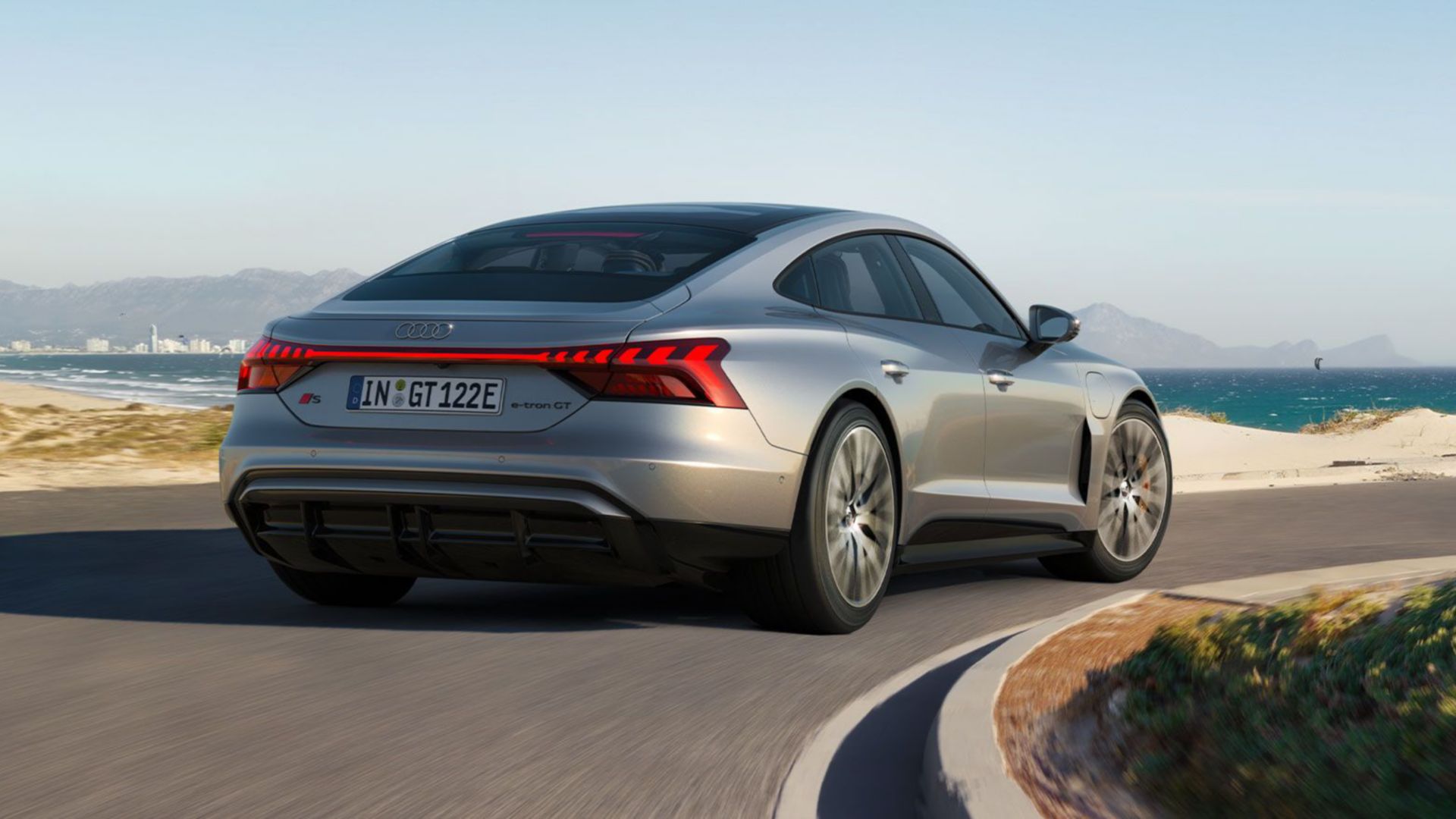 Grauer Audi S e-tron GT Rückansicht auf einer Küstenstrasse