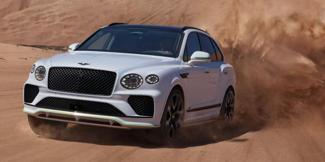 Blauer Bentayga Seite und Front an einem Gebäude am Meer