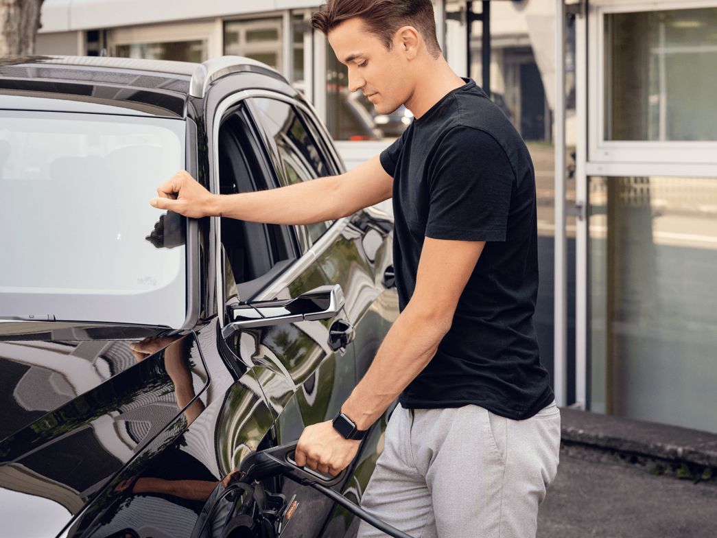 Junger Mann lädt sein Auto