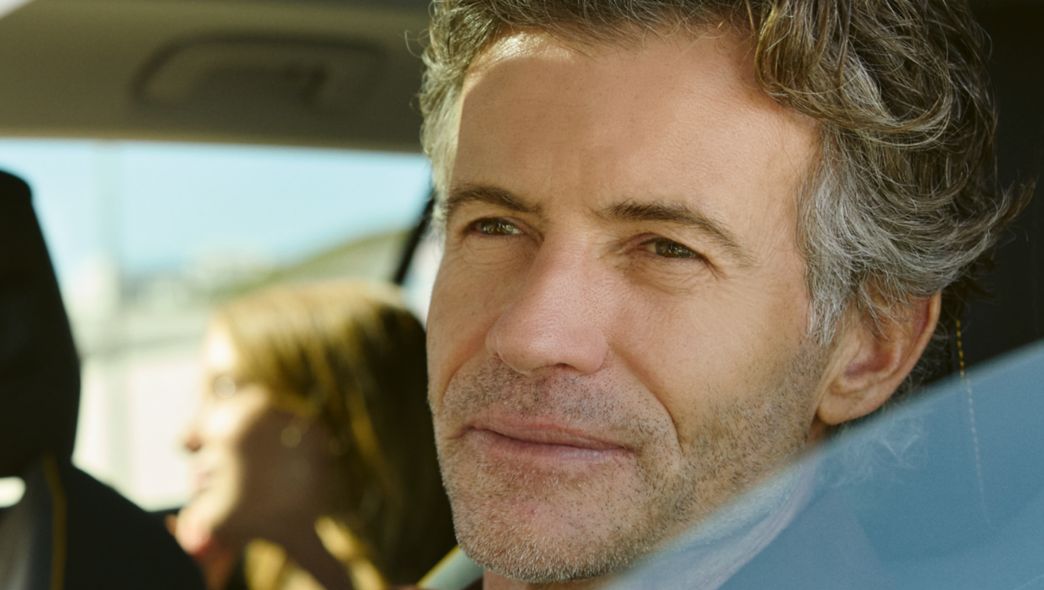 Mann schaut auf dem Auto in die Ferne