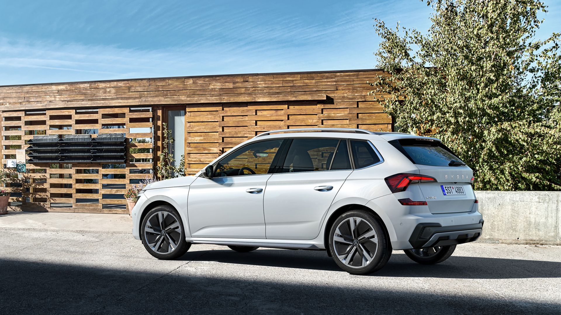 Weisser Skoda Kamiq SUV Seitenansicht vor einem Gebäude