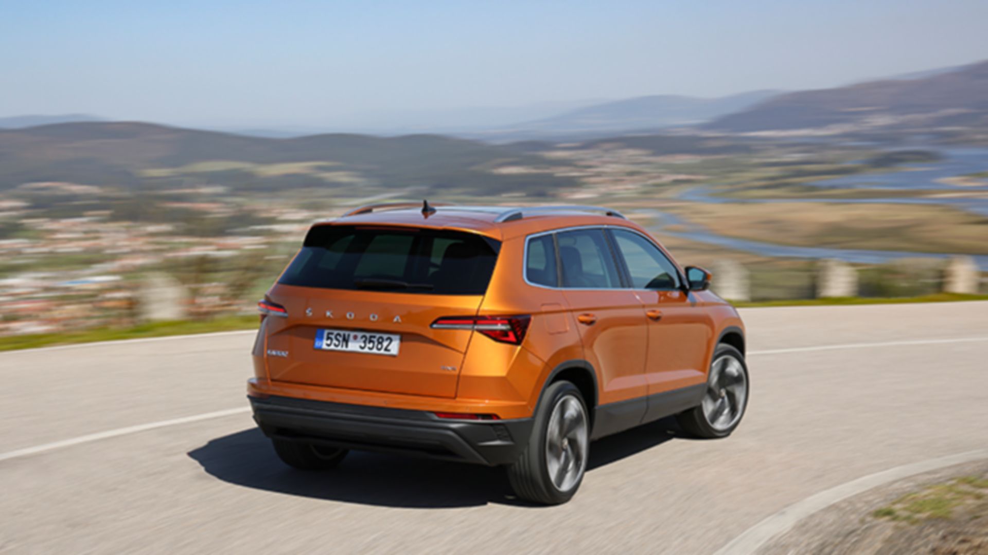 Škoda Karoq orange seitliches Heck auf Strasse