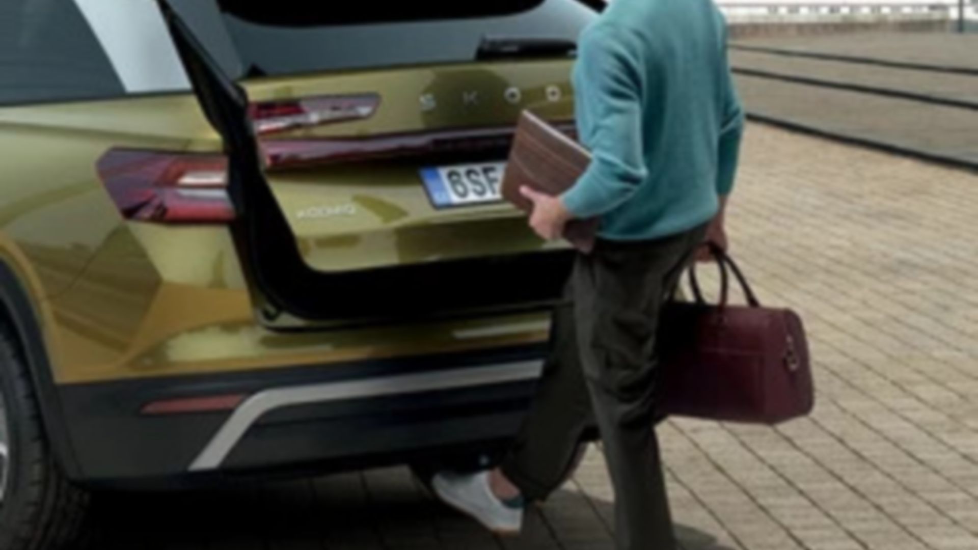 Un uomo apre il bagagliaio del Škoda Kodiaq con un movimento del piede