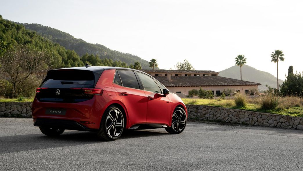 Vue latérale et arrière d’une VW ID.3 GTX rouge avec des palmier