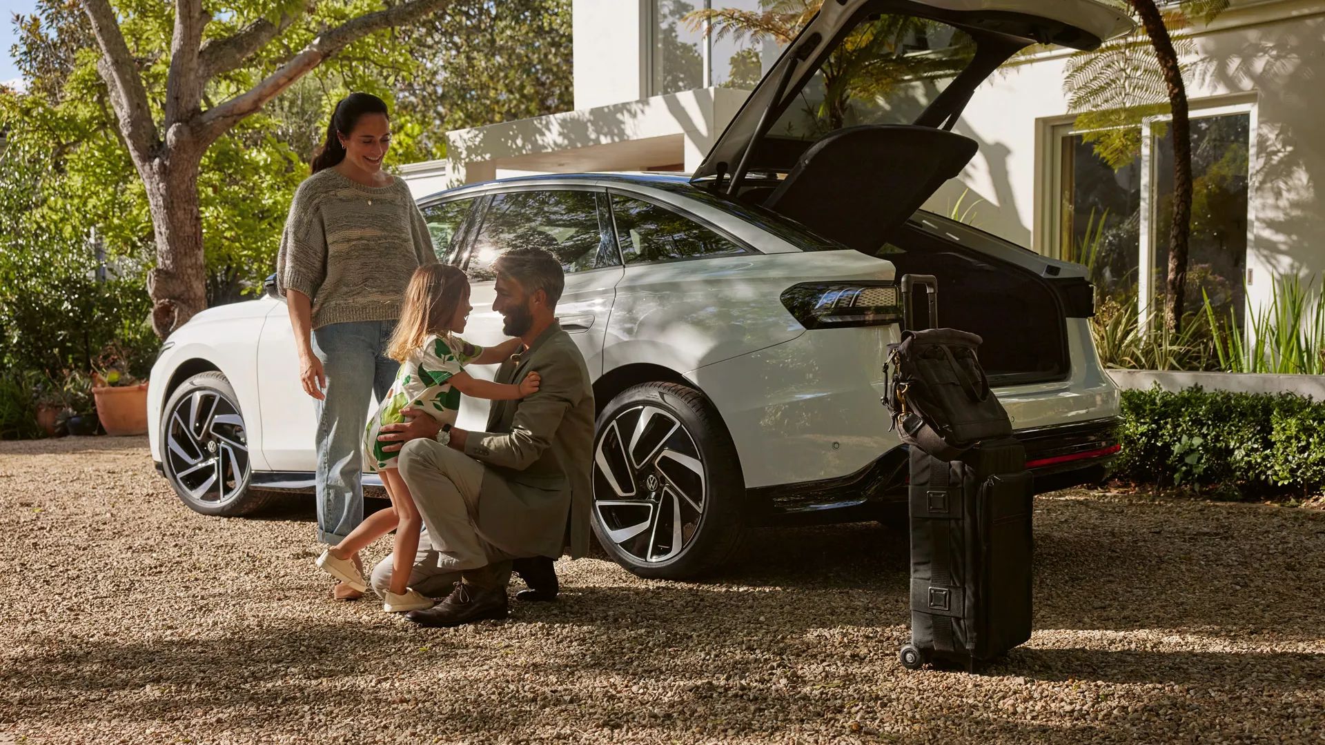 Familie neben dem VW ID.7 mit geöffnetem Kofferraum 