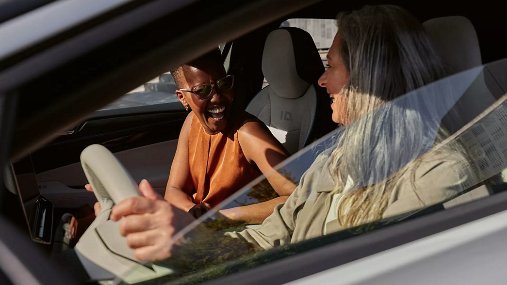 Two women sitting laughing in the VW ID.7