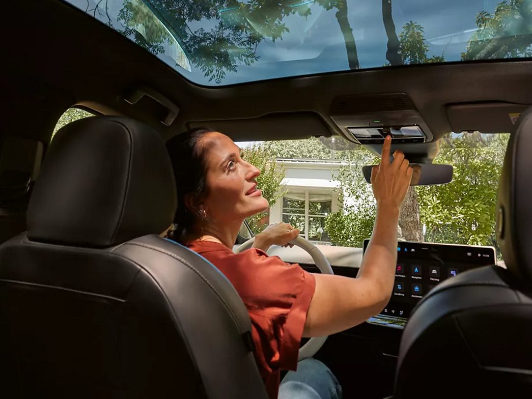 Woman operates panoramic glass roof of the VW ID.7 