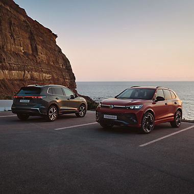 Two VW Tiguan on cliff, front and rear view