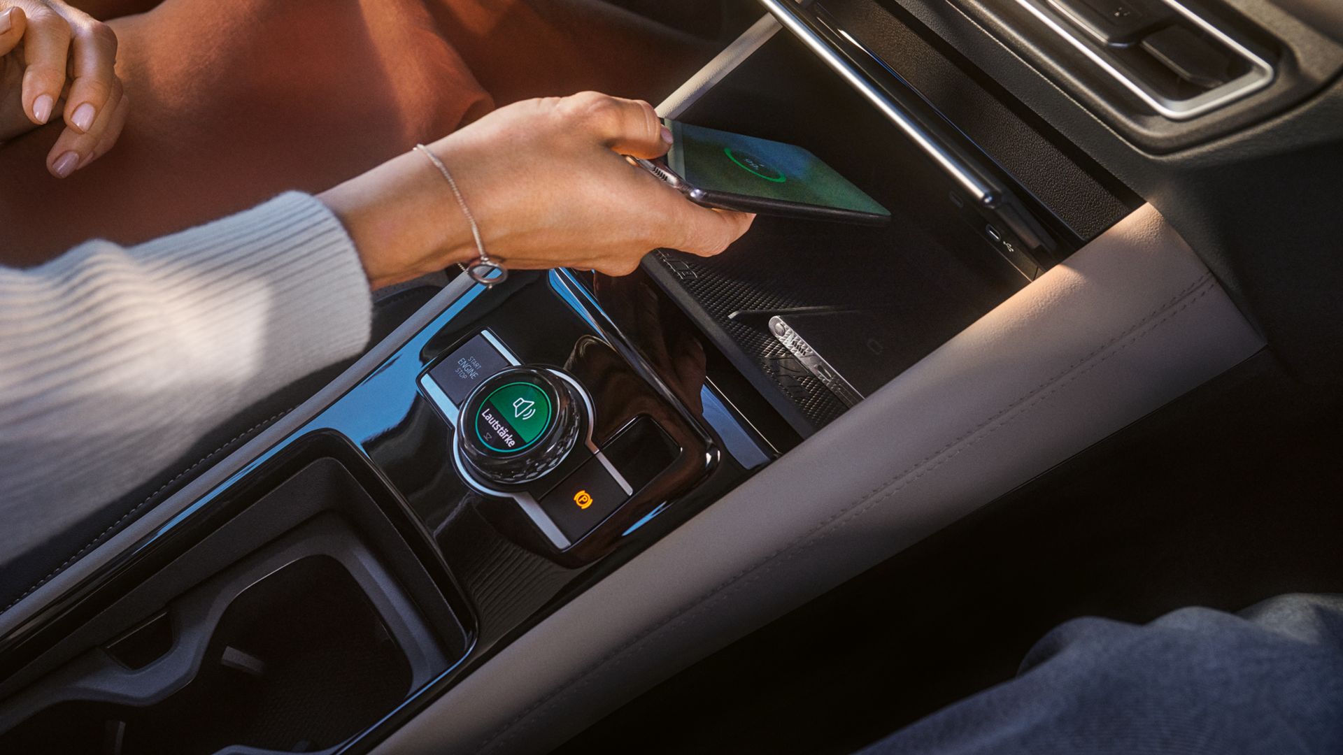 Frau legt Smartphone in Ladeschale im VW Tiguan