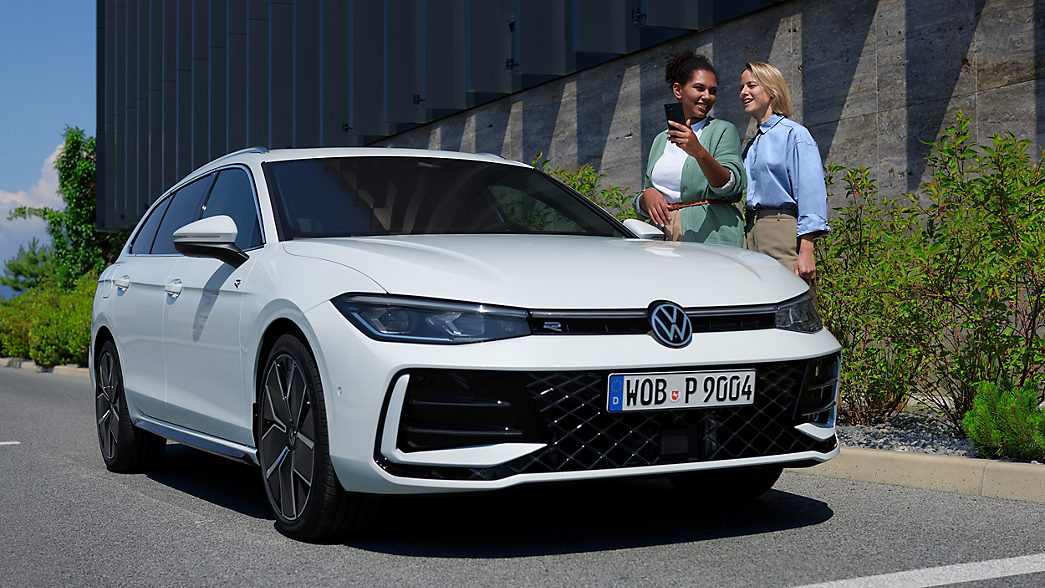 Front view of the new VW Passat with two women next to it