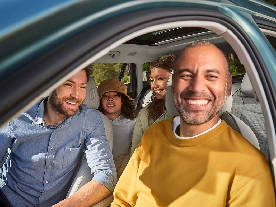 Two men and two children laughing inside the new VW Passat 