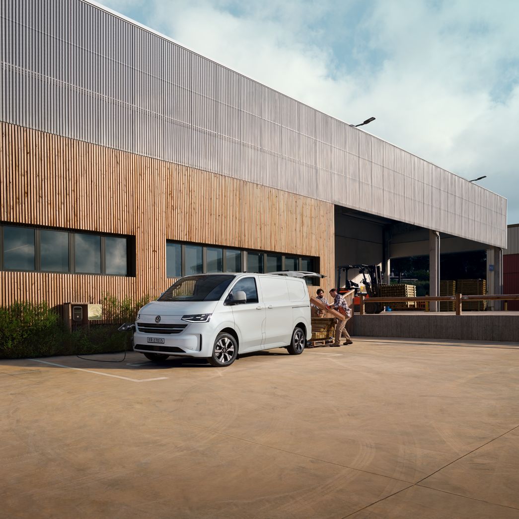 VW Transporter blanc vue de face et latérale devant une maison