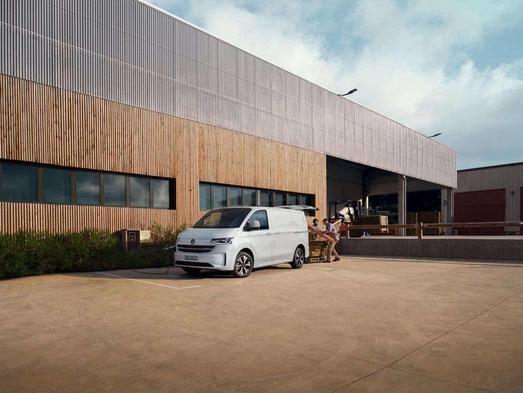 Weisser VW Transporter Seitenansicht vor einem Gebäude