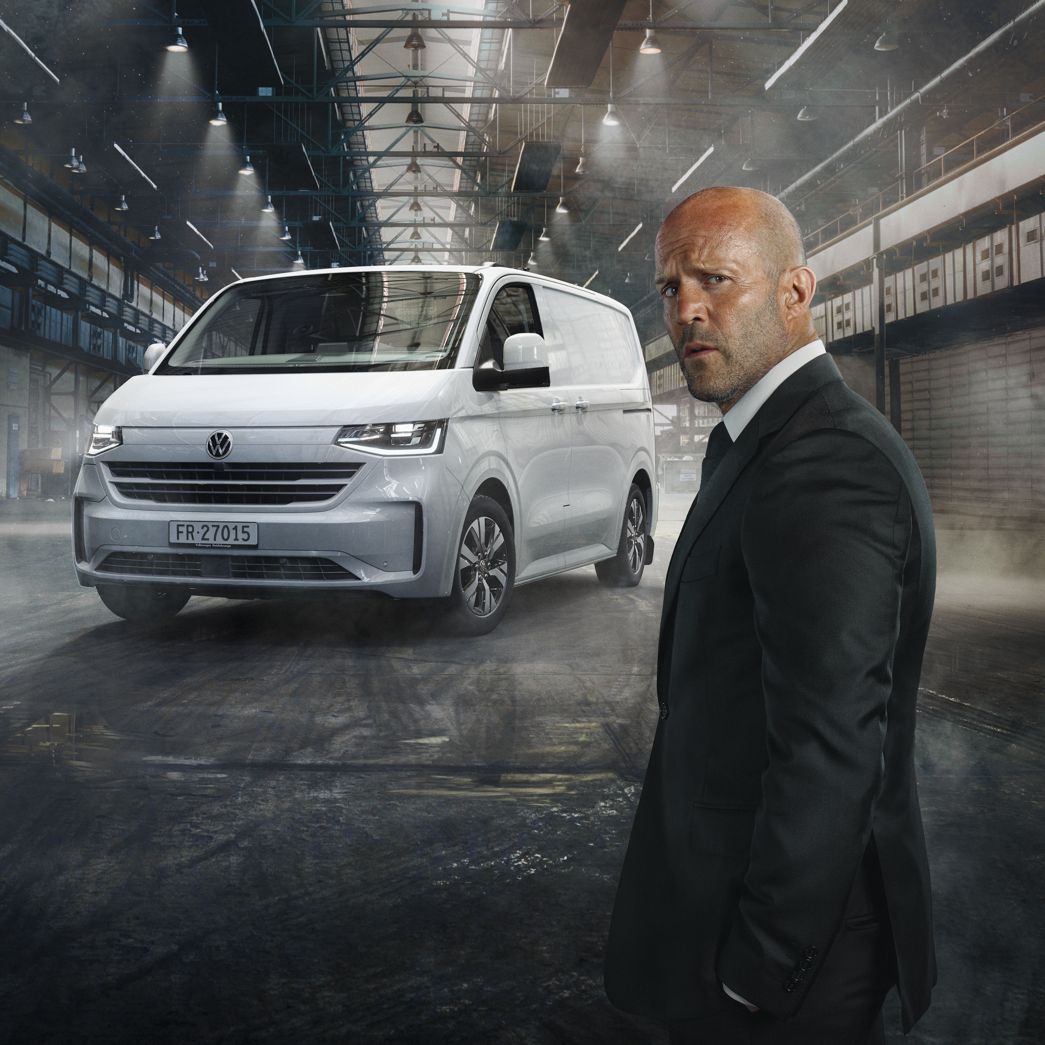VW Transporter blanc vue de face avec Jason Statham à côté