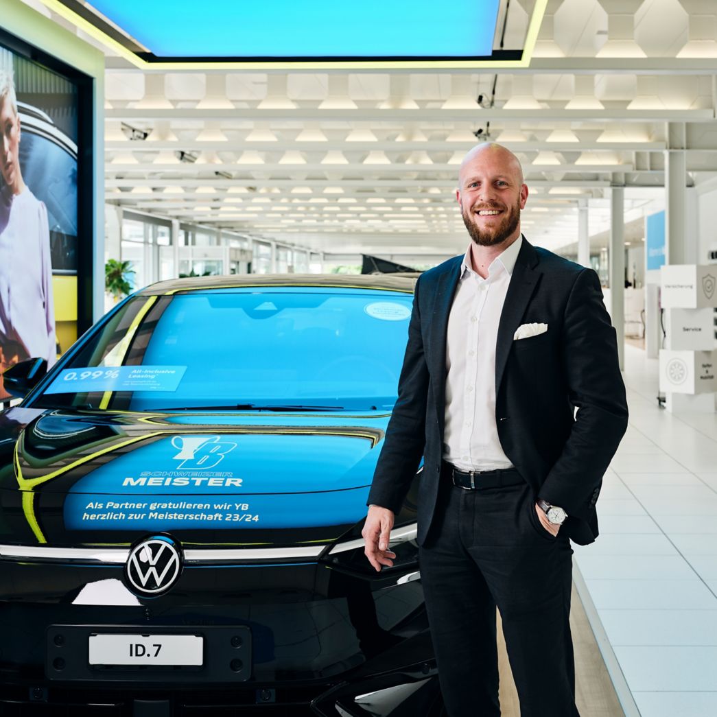 VW ID.7 Frontansicht mit Adrian Ringgenber daneben