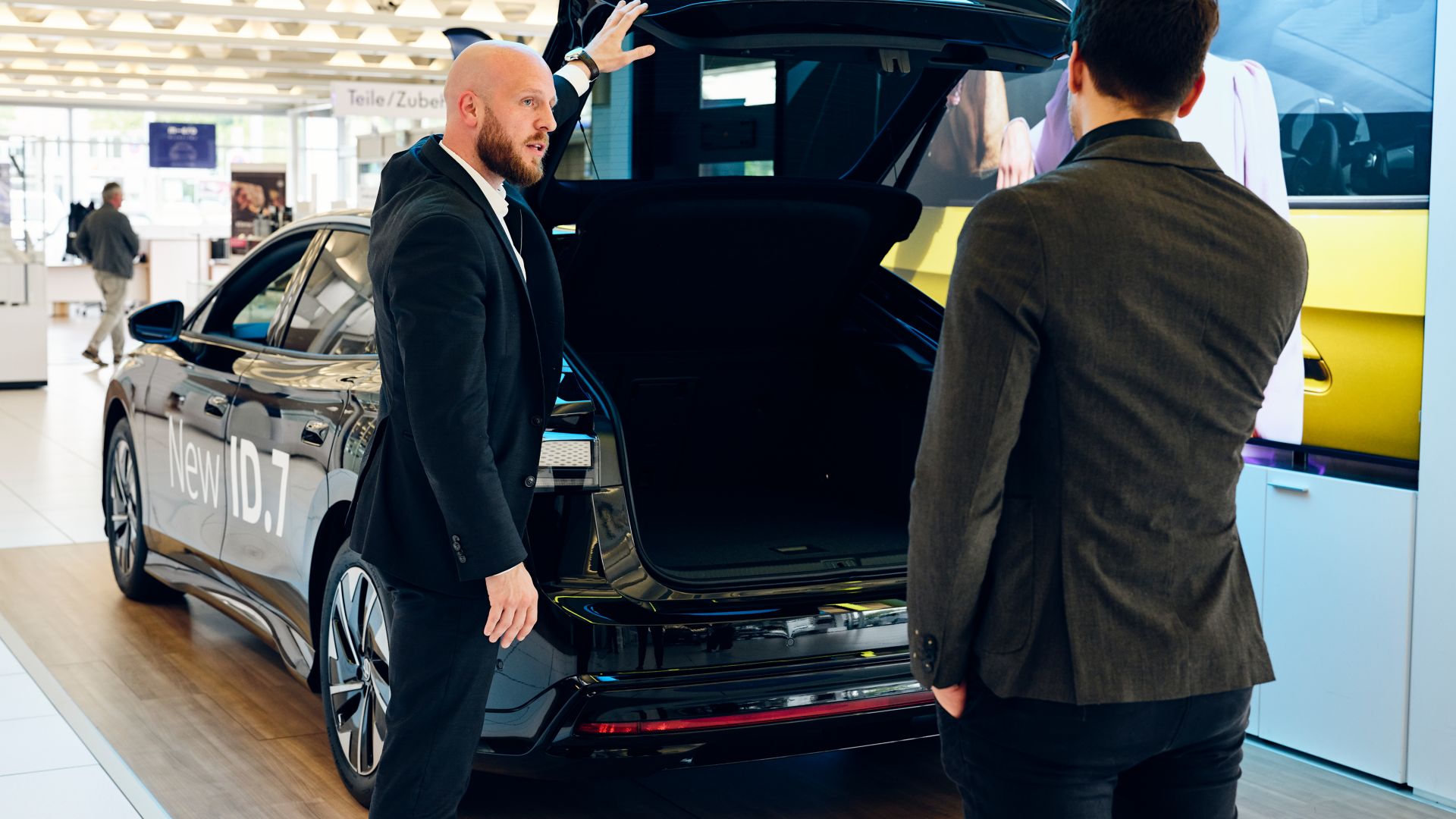 Adrian Ringgenberg, sales consultant AMAG with a customer and the VW ID.7