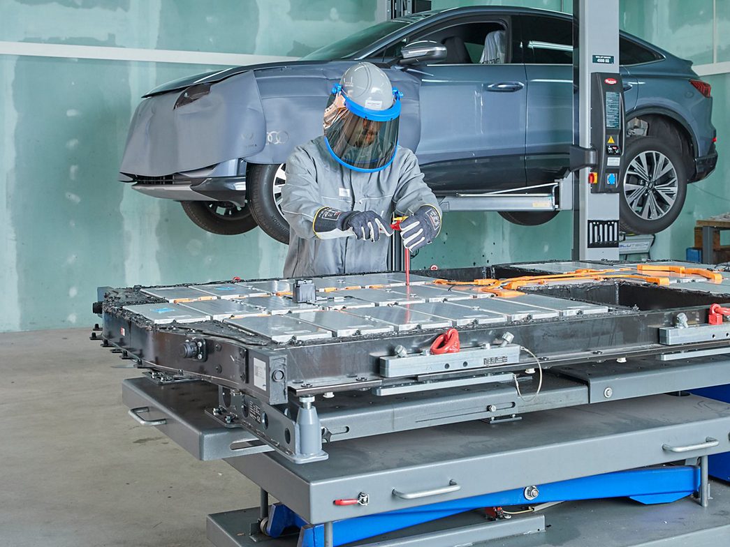 High-voltage technician working on electric vehicle battery 