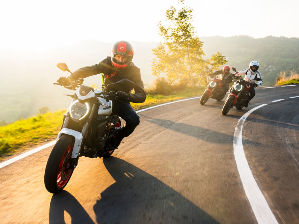 Motorrad Fahrer bei Sonnenschein im Kurve, weitere dahiner