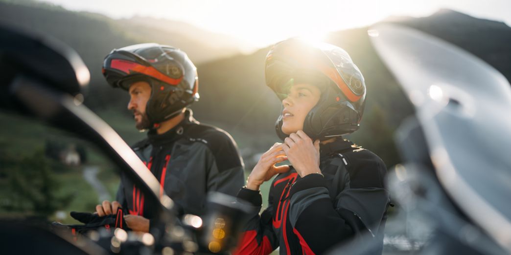 Ducati Fahrer und Fahrerin ziehen Helm an