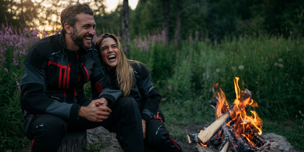 Paar lachend am Lagerfeuer