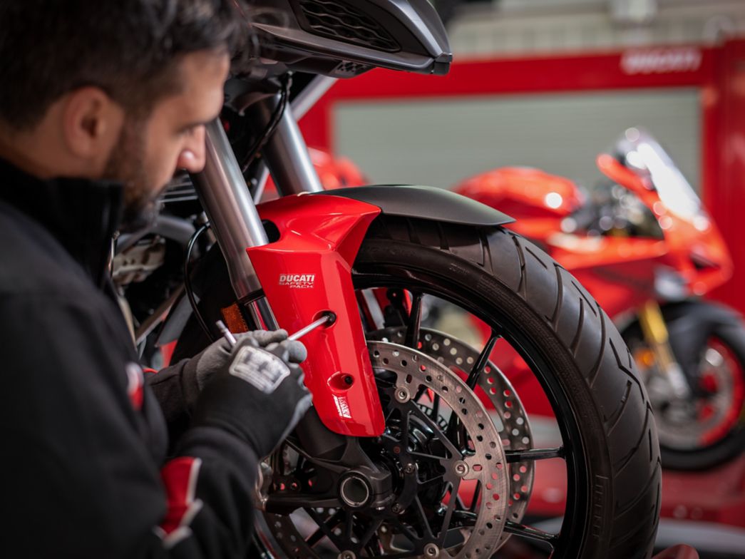 Un uomo lavora a una Ducati con un cacciavite